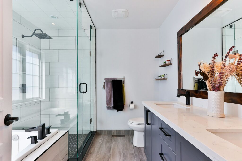 Remodeled bathroom with glass shower, floating vanity and wood-framed mirror