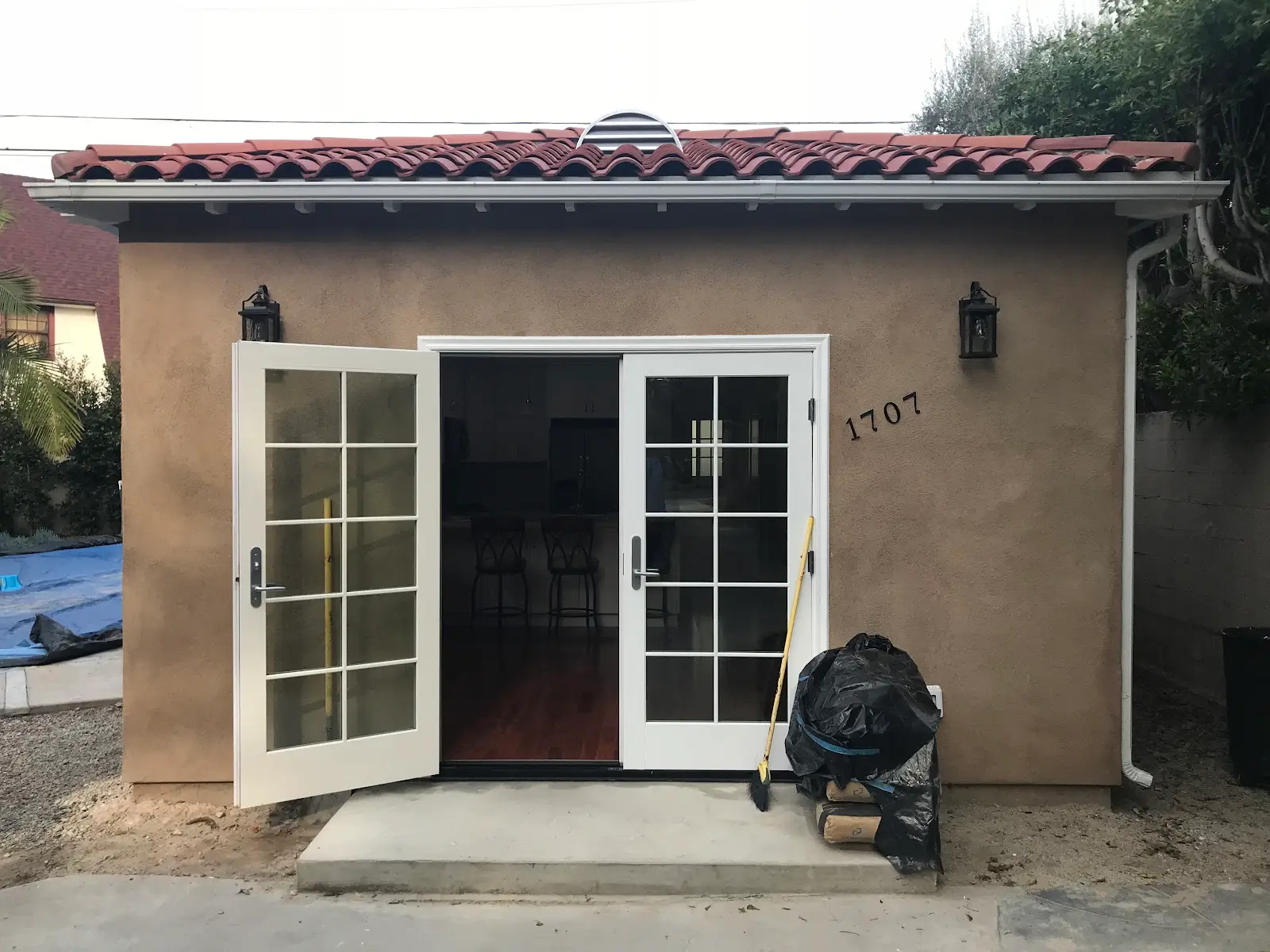 Finished detached ADU with a clay tile roof and French doors opening onto the yard in West Hollywood
