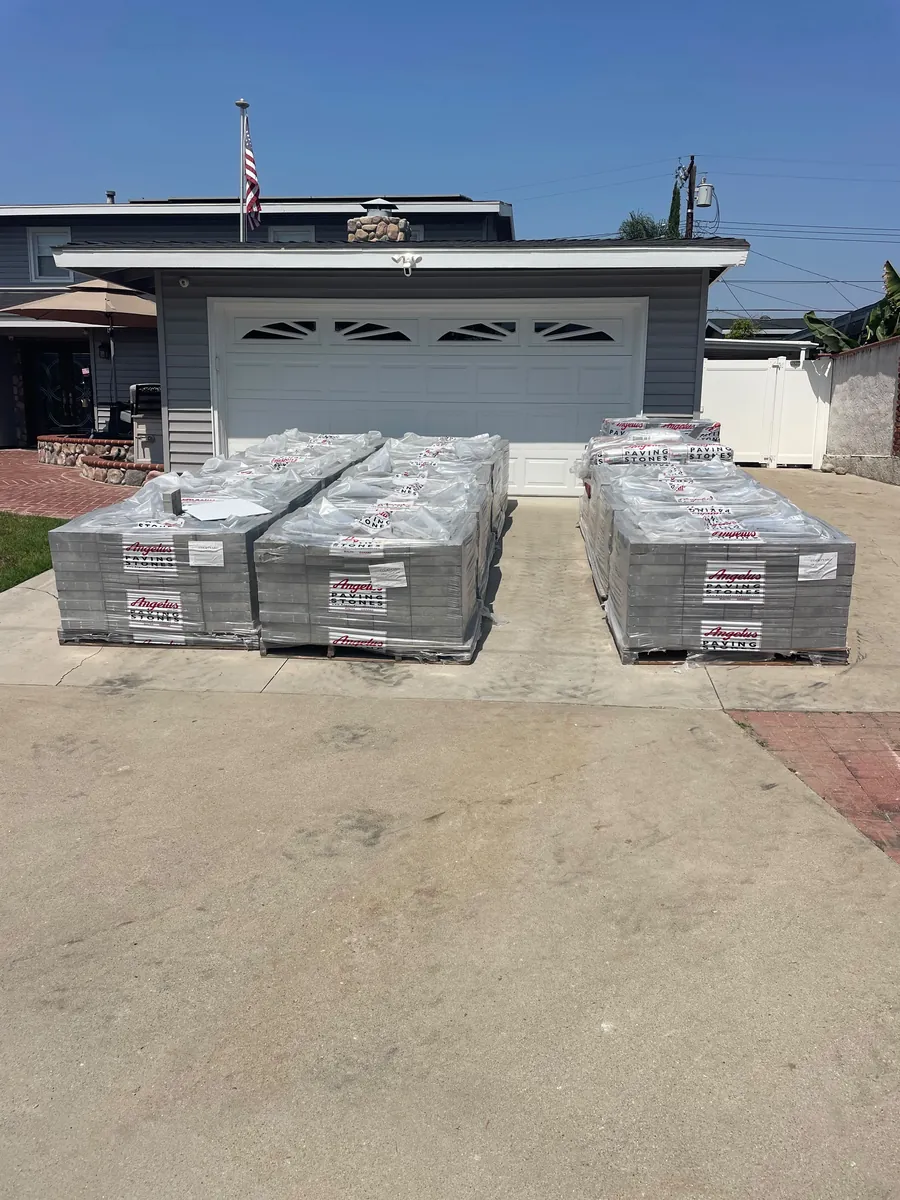 Angelus Paving Stones pallets staged on the driveway before the decking went down