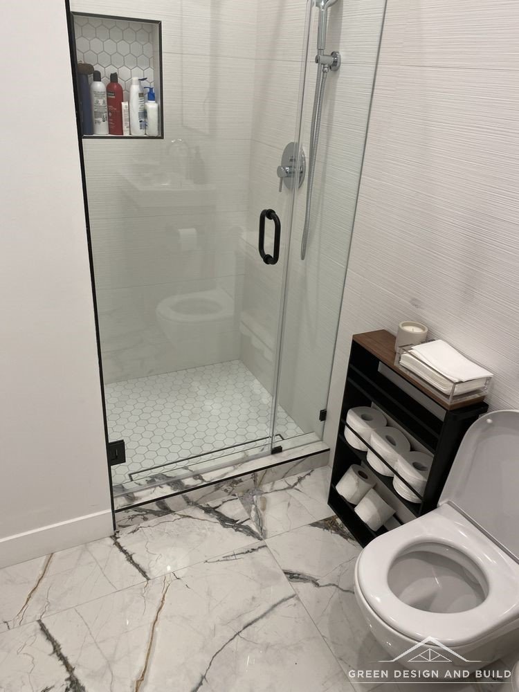 Frameless glass shower enclosure opening onto marble floor tile in a Diamond Bar bathroom