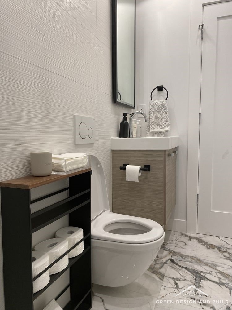 Compact bathroom with a wood-effect vanity, wall-hung toilet and large-format marble floor tile in Diamond Bar