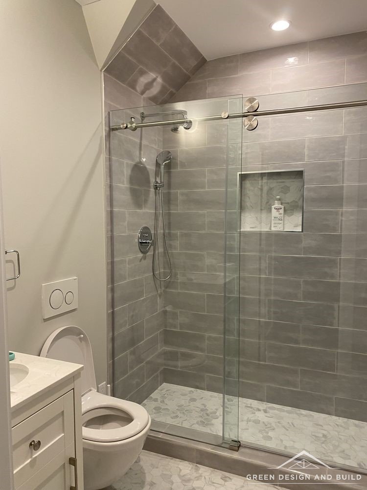 Tiled walk-in shower behind sliding glass doors with brushed hardware in a Diamond Bar bathroom