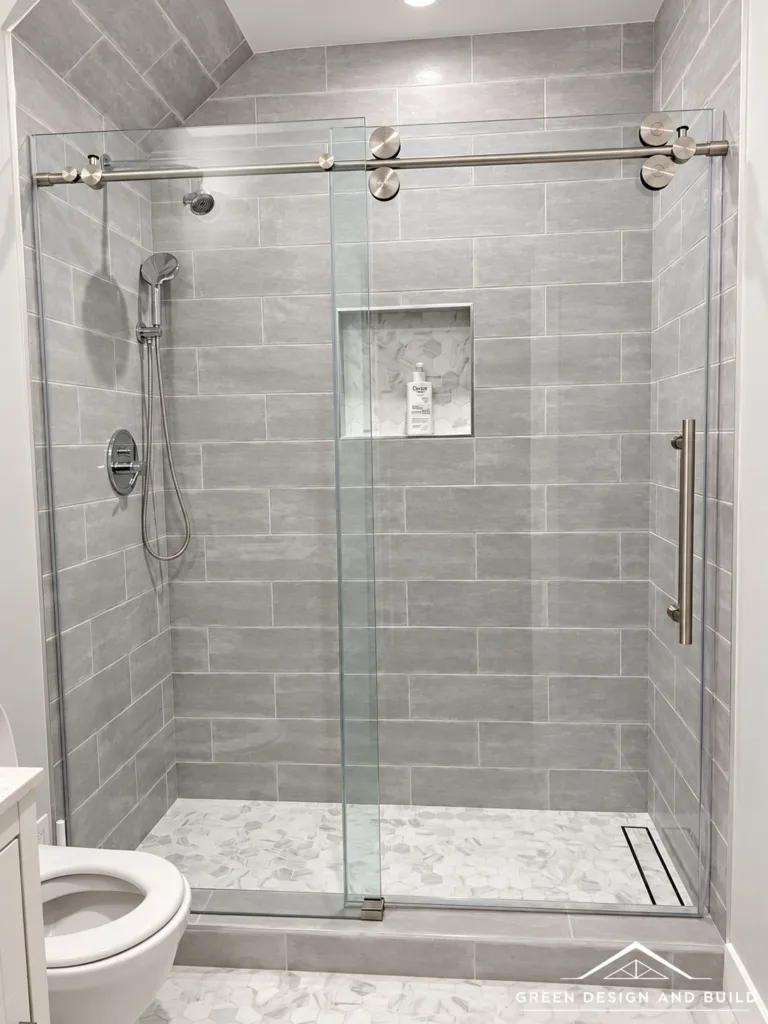 Walk-in shower with gray stone-look tile, a recessed niche and sliding glass in a Diamond Bar bathroom