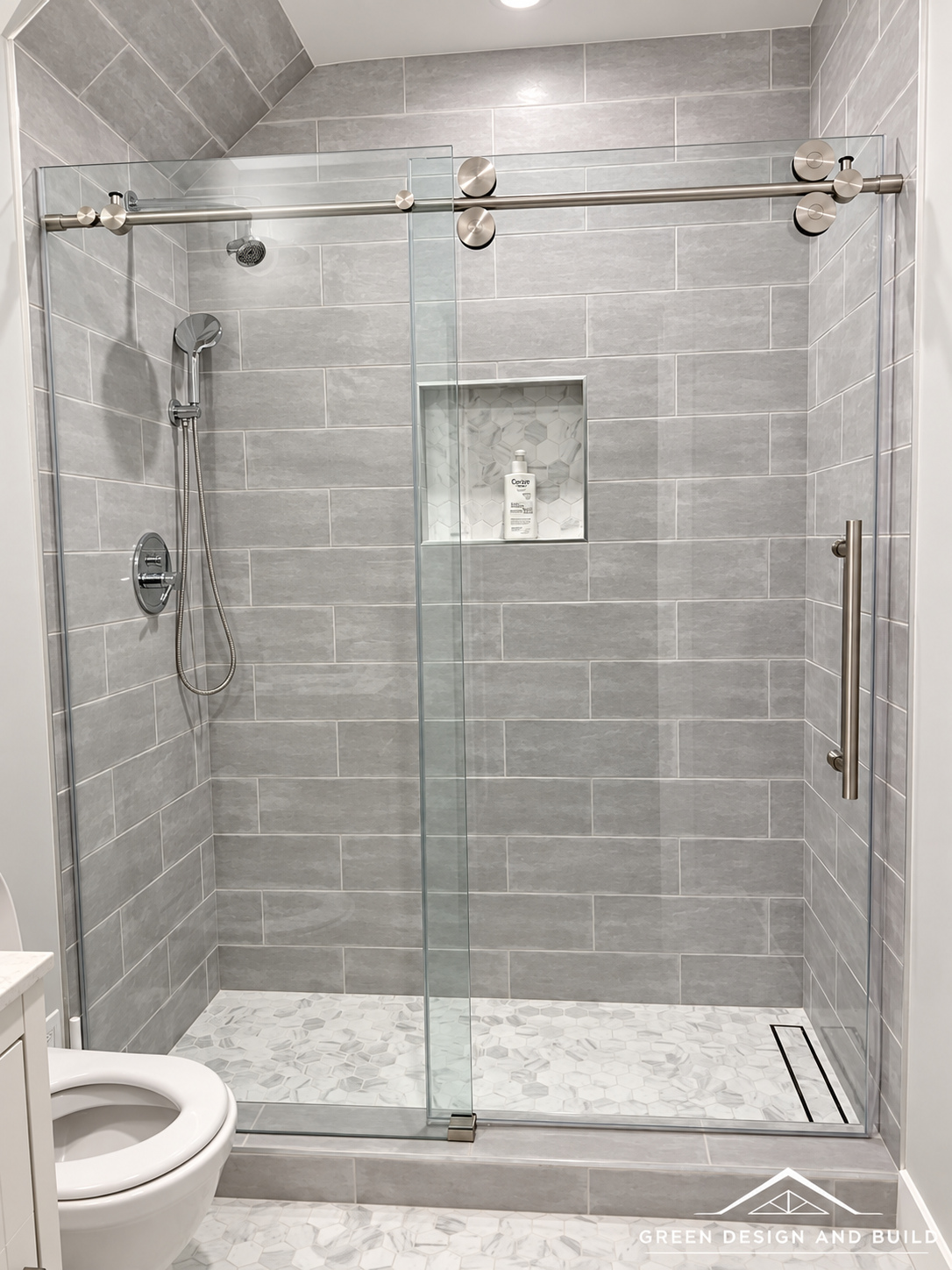 Walk-in shower with gray stone-look tile, a recessed niche and sliding glass in a Diamond Bar bathroom
