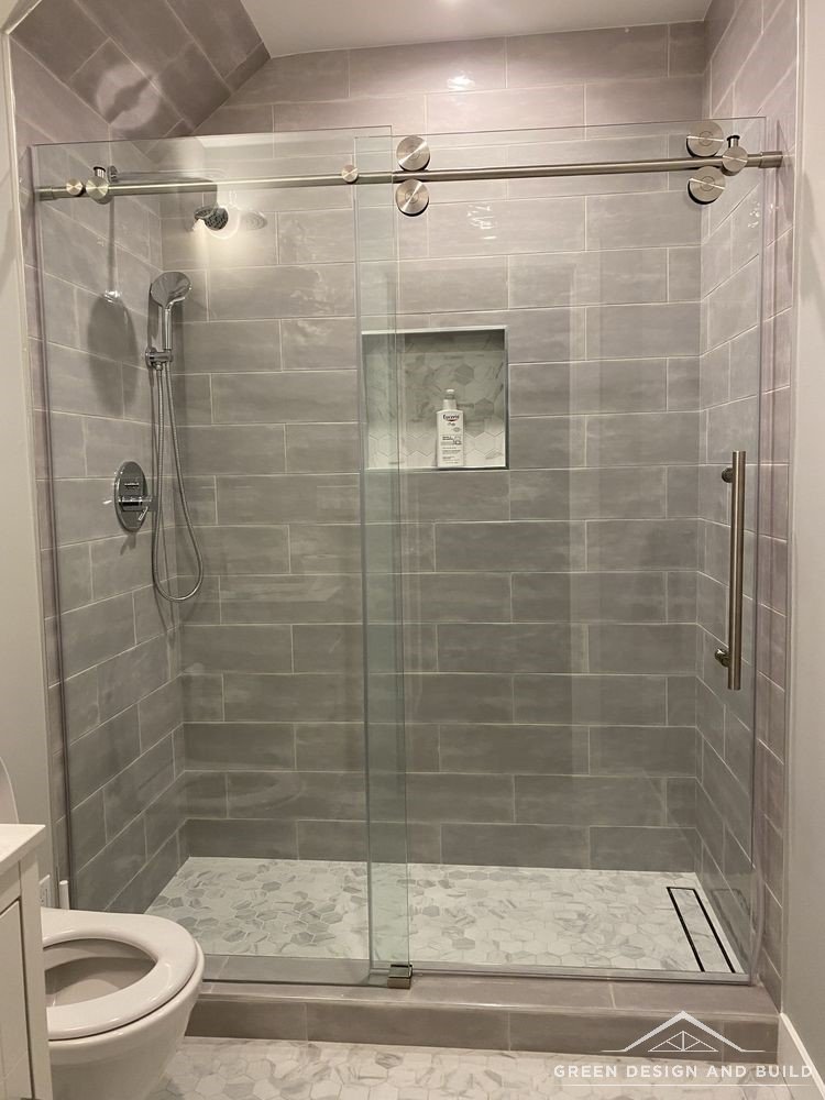 Walk-in shower with grey stone-look tile, a recessed niche and sliding glass in a Diamond Bar bathroom