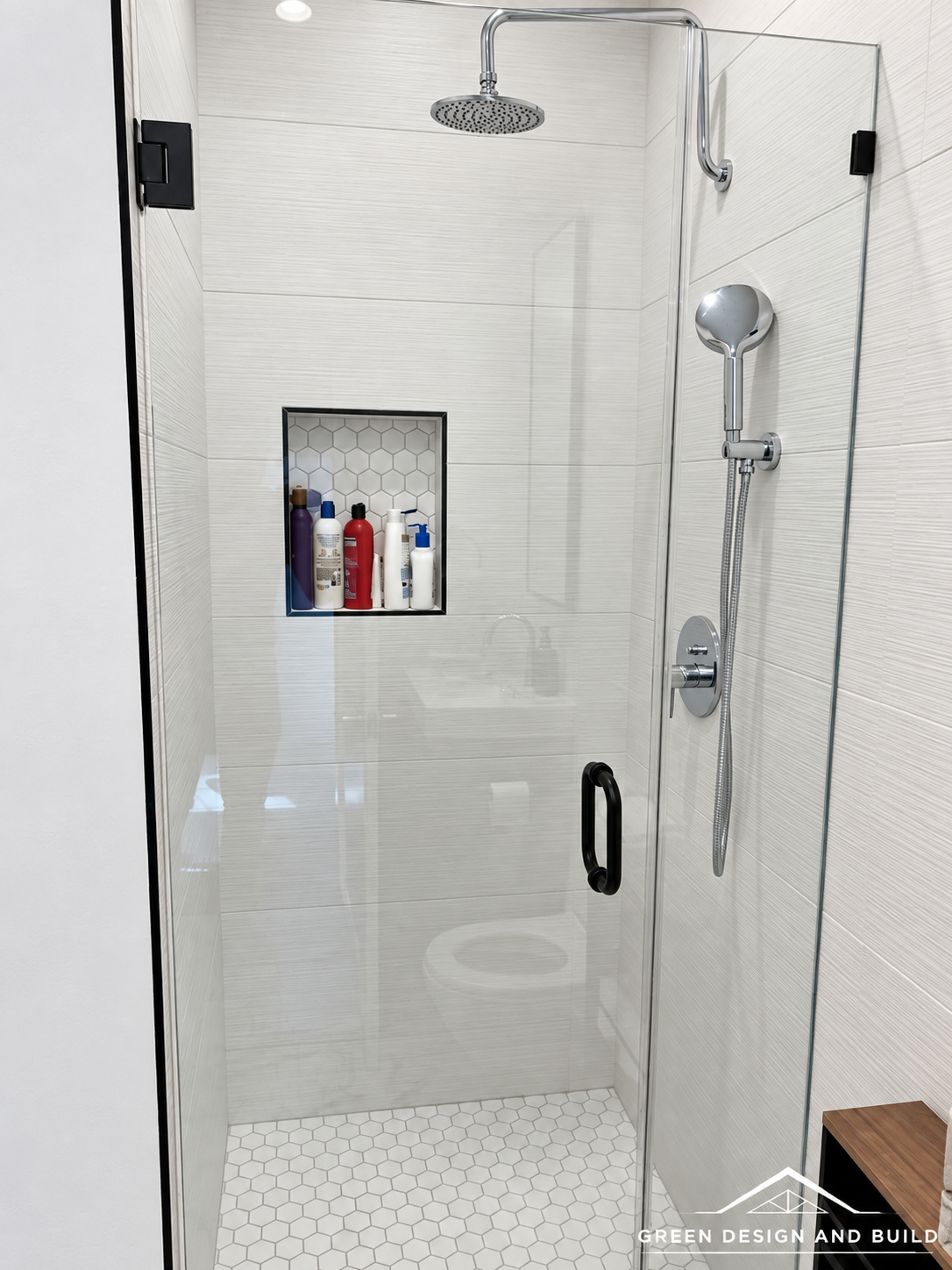Frameless corner shower with a rainhead and recessed niche in a Diamond Bar bathroom