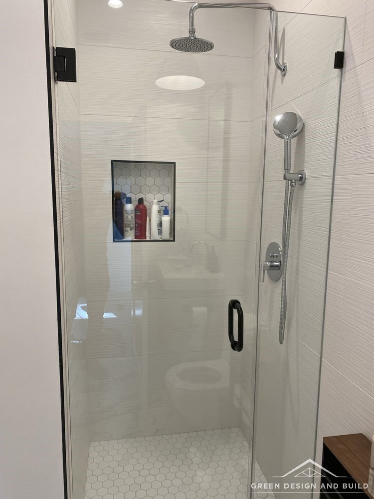 Frameless corner shower with a rainhead and recessed niche in a Diamond Bar bathroom