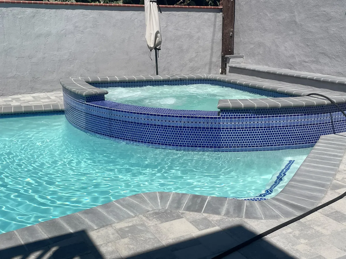 Coping set and paver decking part-laid around the finished pool shell