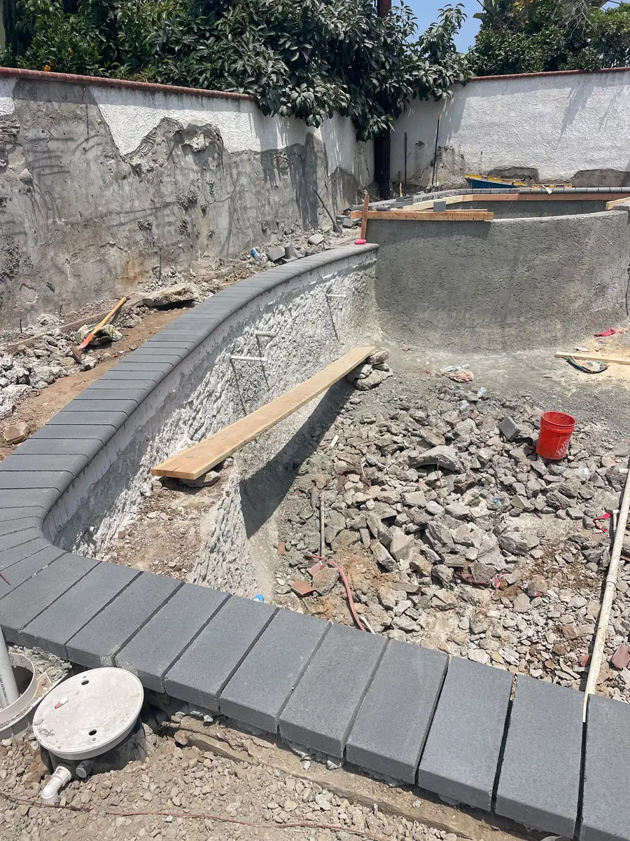 Shotcrete shell after placement, with rebar ties still exposed at the wall
