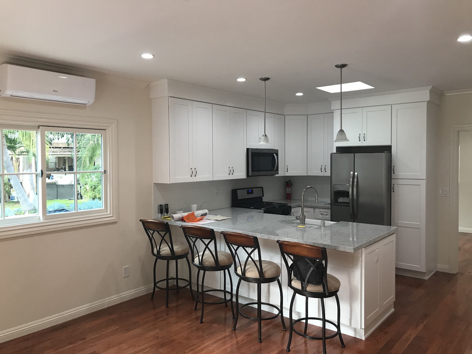 Completed ADU kitchen with stone counters and stainless appliances in a Los Angeles backyard unit