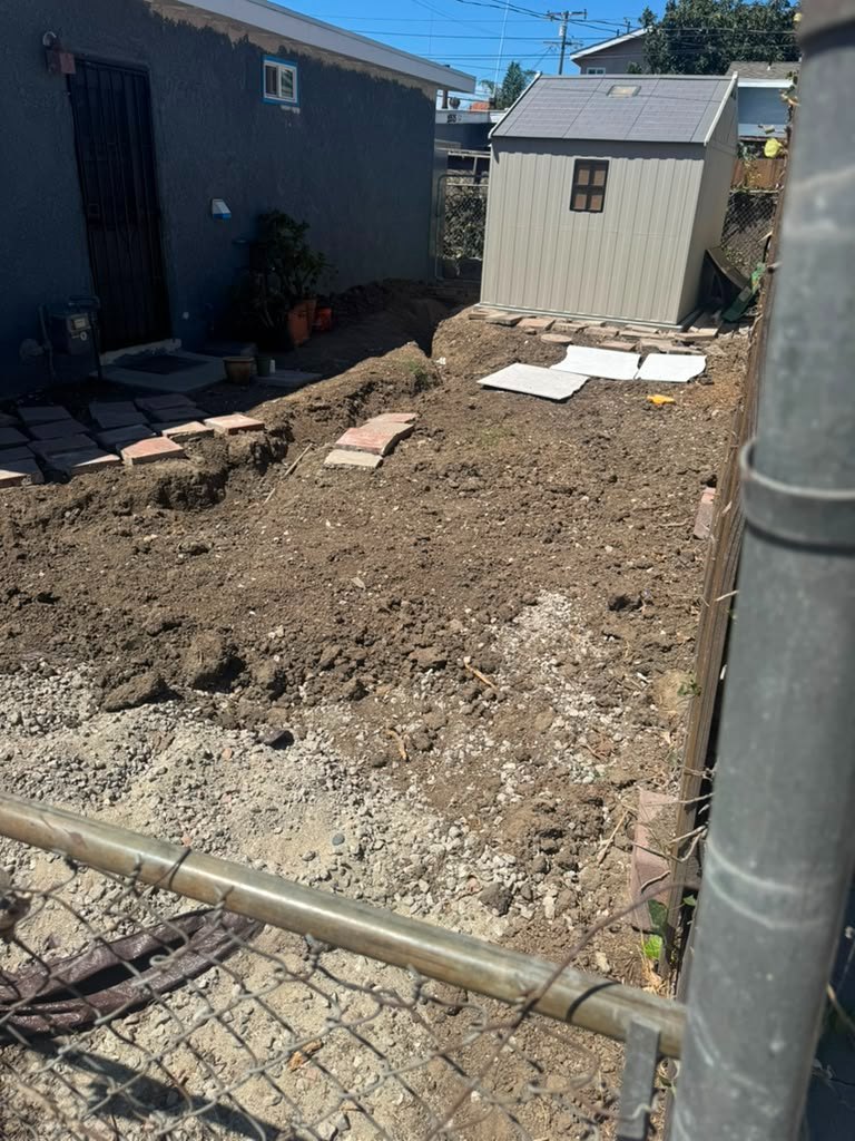 Excavated side yard with compacted aggregate base going down in lifts before pavers, Anaheim
