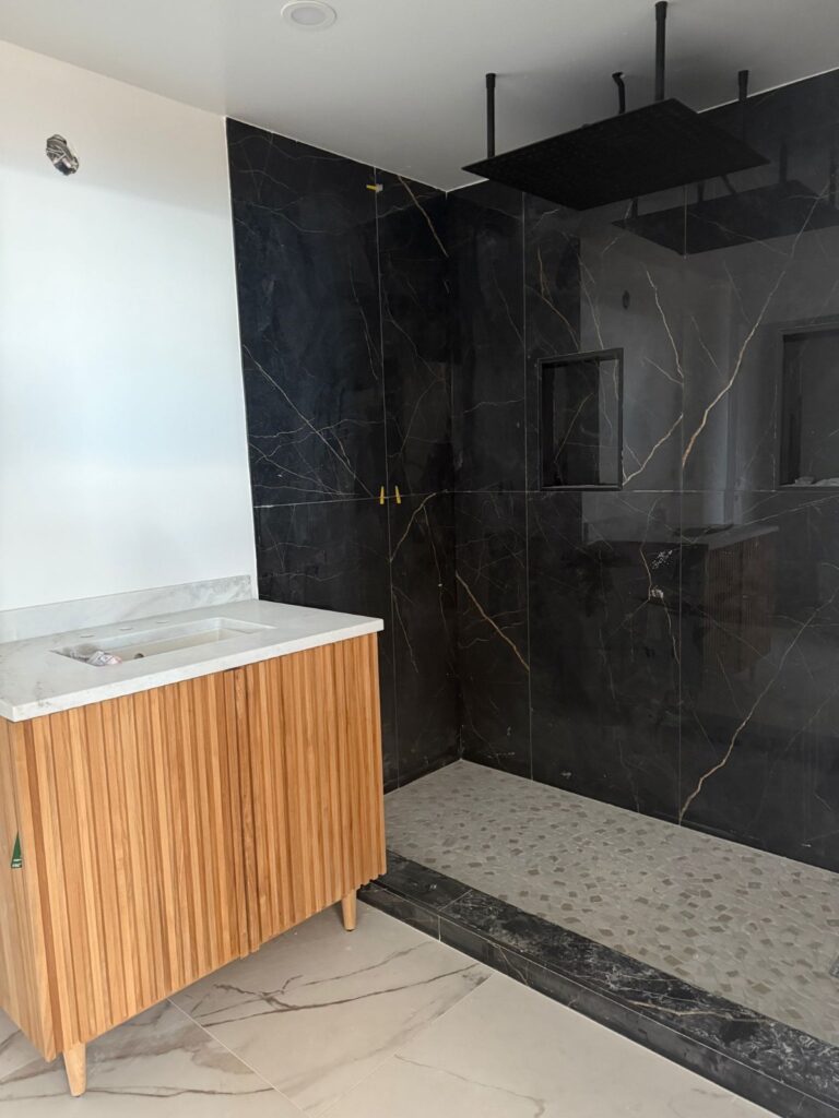 Bathroom: black marble shower — whole-home remodel in Encino, CA