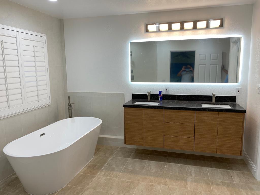 After: floating vanity and lit mirror — bathroom remodel in Irvine, CA