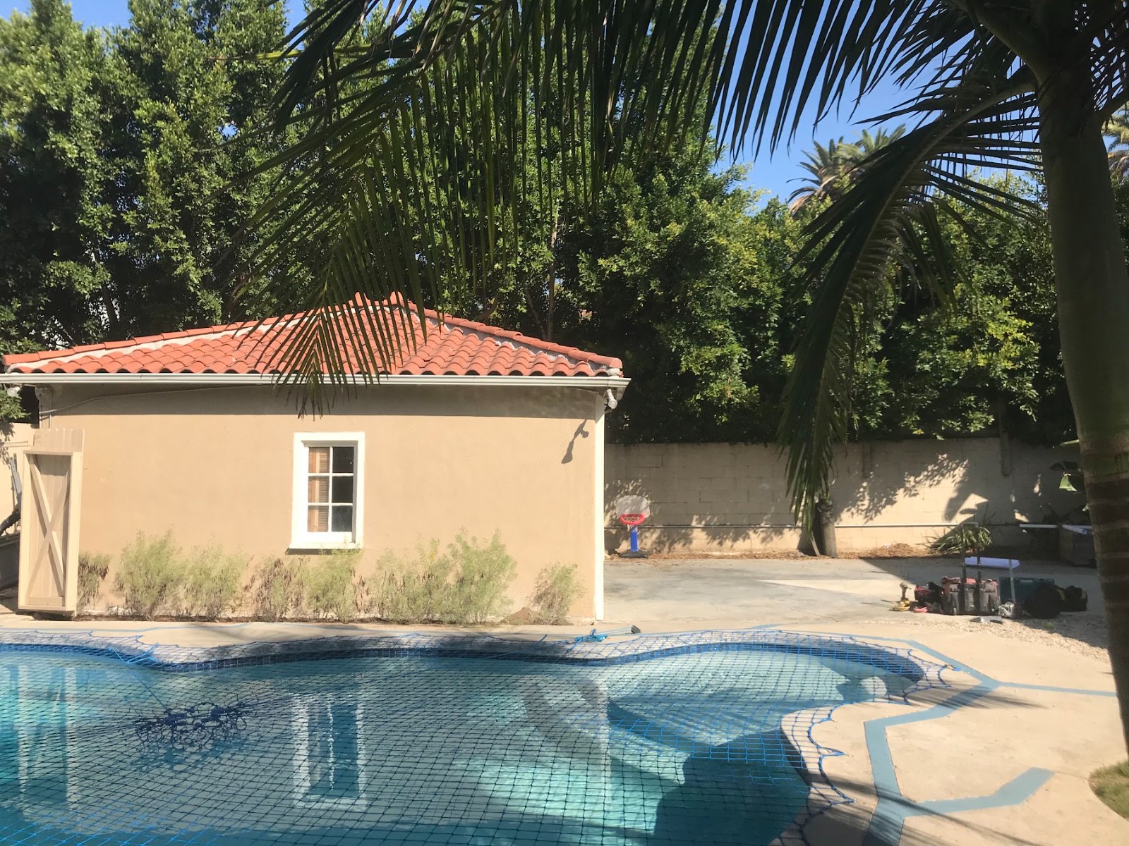 Detached garage beside a pool before conversion into an ADU in Los Angeles