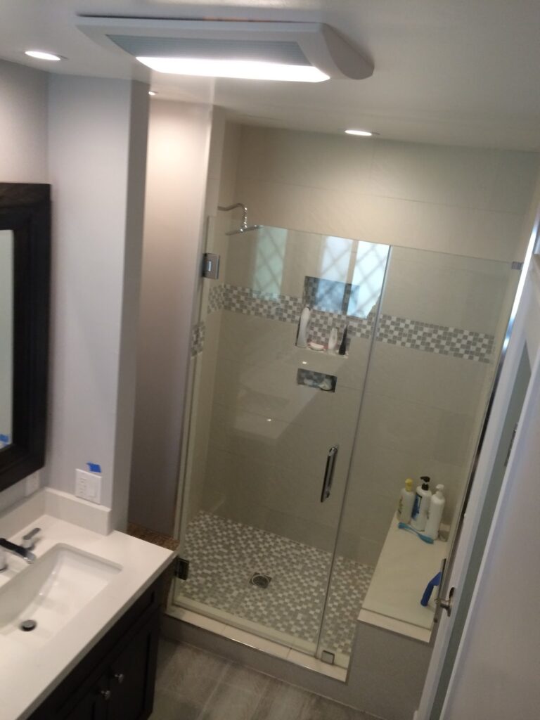After: glass shower with accent band — bathroom remodel in Ontario, CA