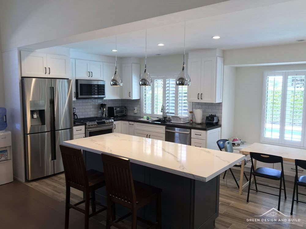 Finished Manhattan Beach kitchen island with bar seating and a quartz waterfall edge