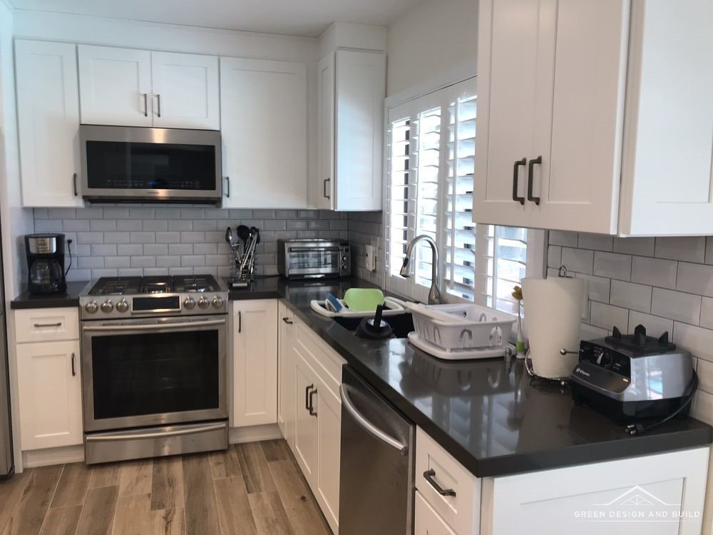 Finished range wall with tile backsplash and dark quartz counters in a Manhattan Beach kitchen
