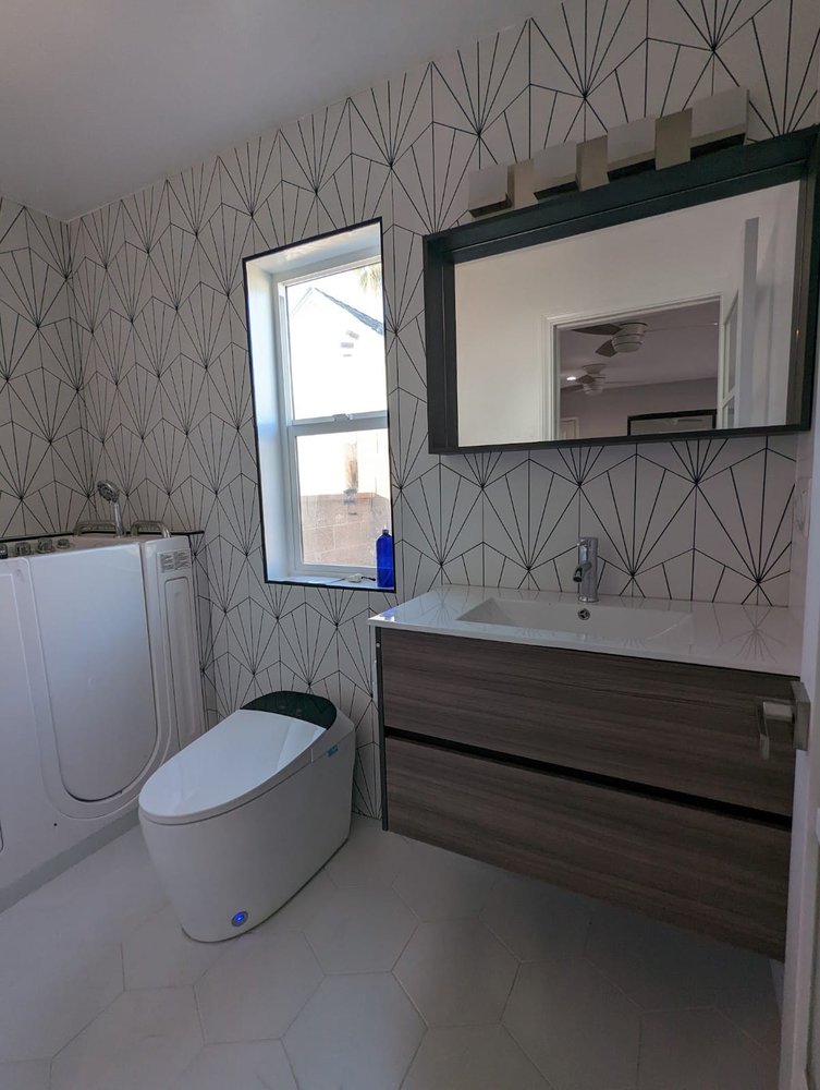 Finished bathroom in a Montebello room addition with patterned wall tile, a floating vanity and a walk-in tub