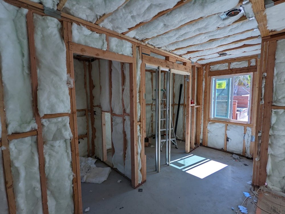 Interior framing with spray foam insulation applied inside a Montebello room addition