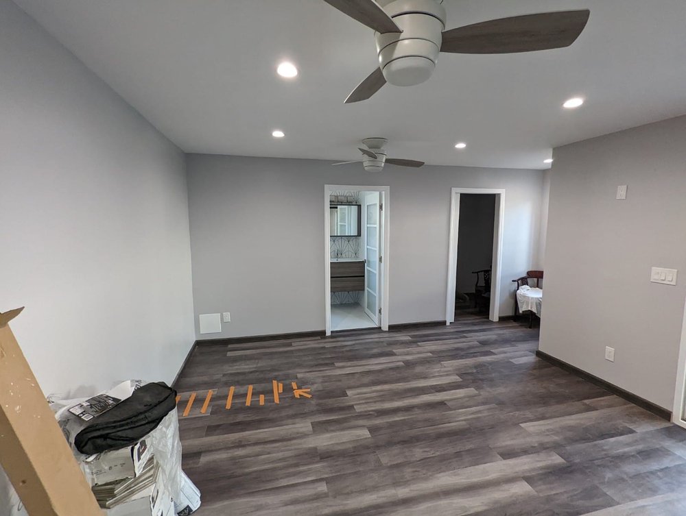 Finished room addition interior with plank flooring, recessed lighting and a ceiling fan in Montebello