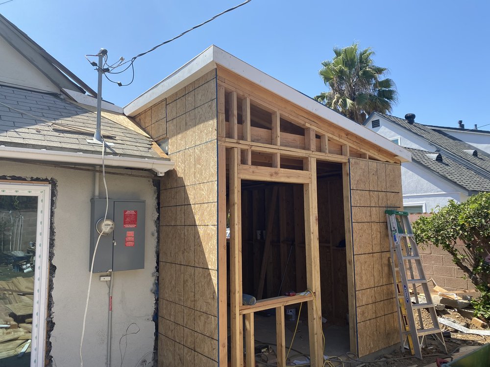 Wall sheathing and framed door opening on a room addition under construction in Montebello