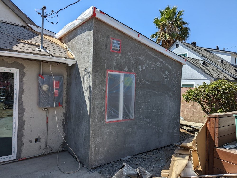 Stucco exterior with taped window openings on a room addition under construction in Montebello