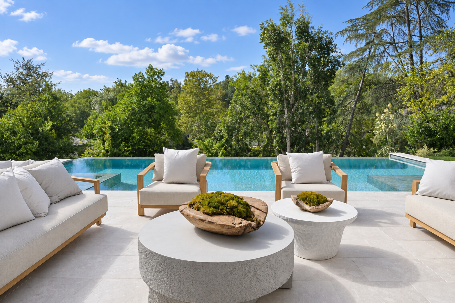Large-format limestone pool deck with lounge seating and a raised spa at a Hidden Hills home built by Green Design and Build