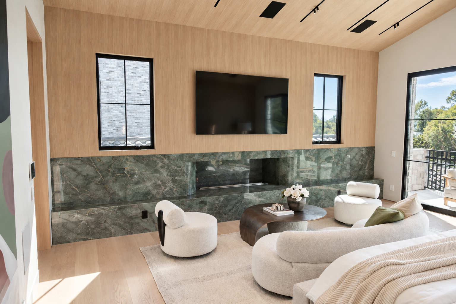 Primary bedroom with a green marble fireplace wall, vaulted white oak ceiling and steel balcony doors