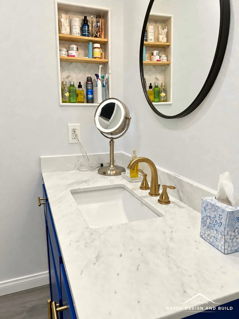 Finished bathroom with a navy vanity, oak shelving and a tiled walk-in shower in West Hollywood