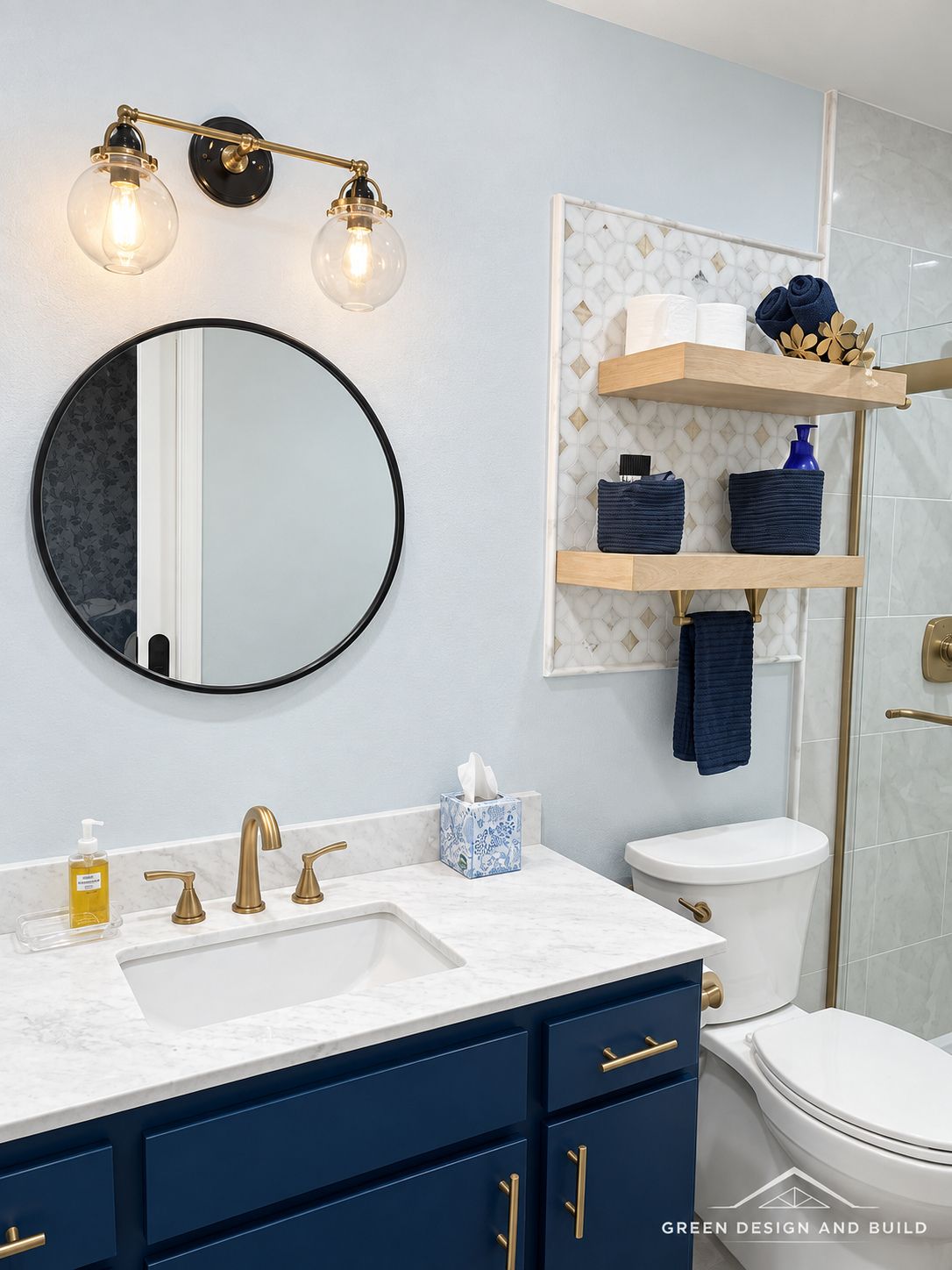 Navy shaker vanity with brass hardware, marble-look counter and a round black mirror in a West Hollywood bathroom