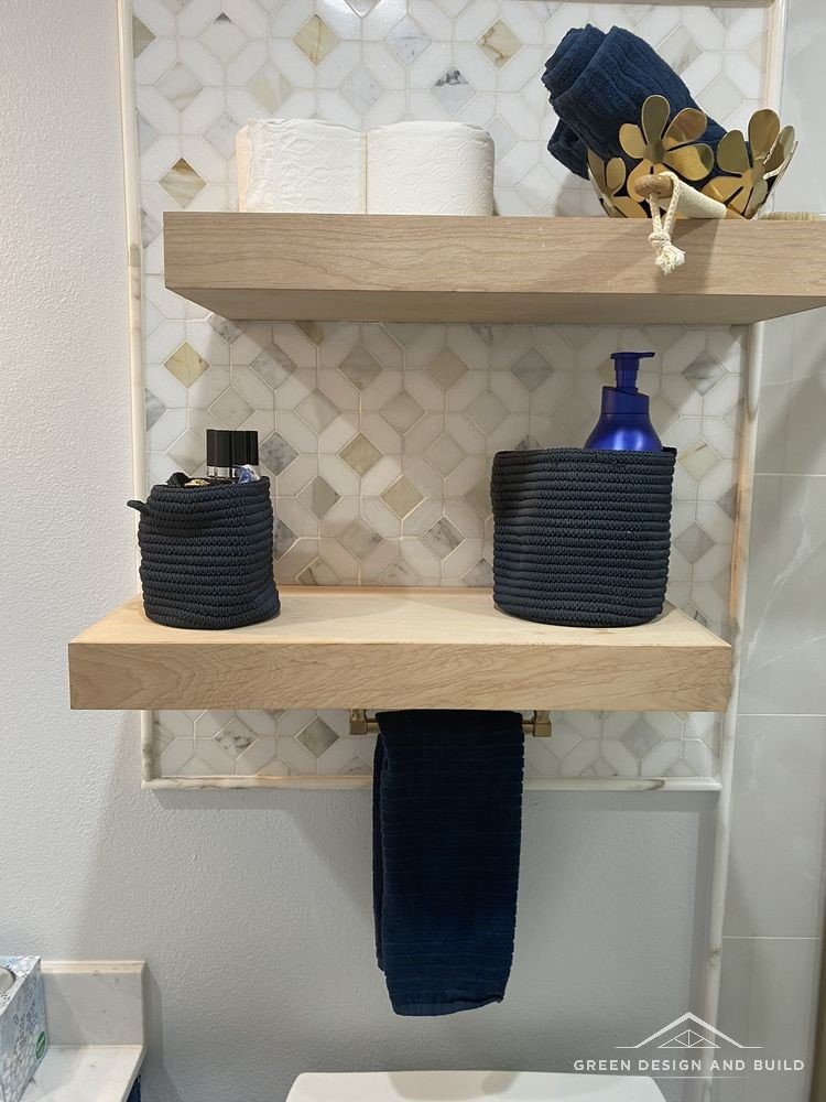 Floating white oak shelves against a mosaic tile accent wall in a West Hollywood bathroom
