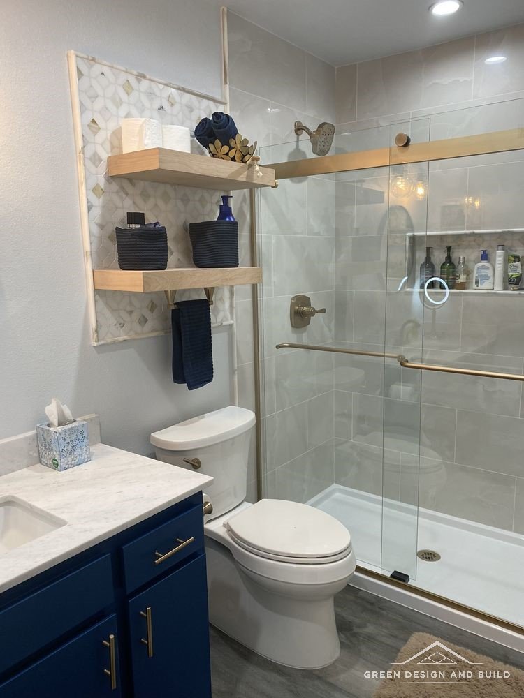 Tiled shower behind sliding glass beside a navy vanity in a remodelled West Hollywood bathroom