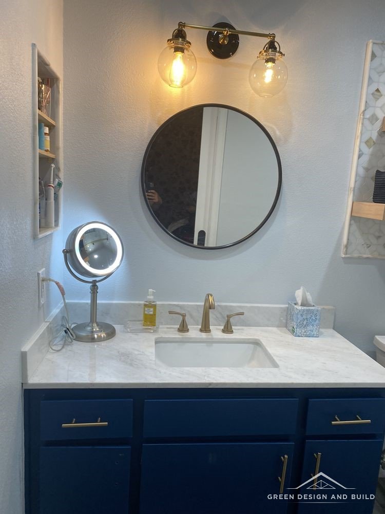 Marble-look counter, undermount basin and brass tap on a navy vanity in a West Hollywood bathroom