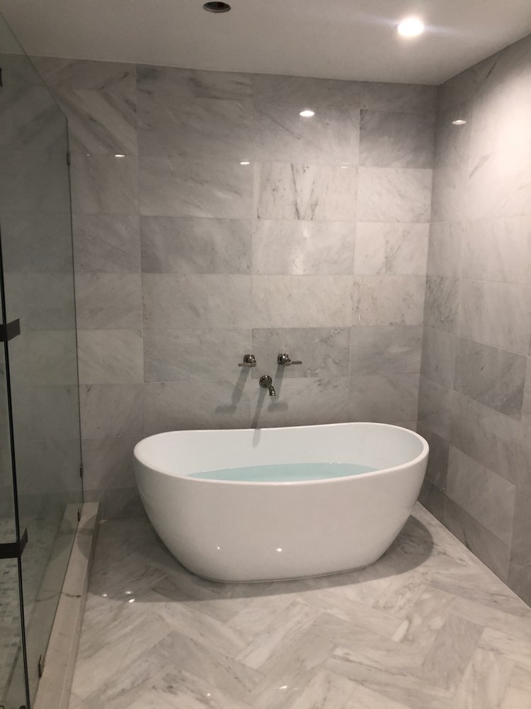 Finished primary bathroom with a freestanding tub and large-format marble tile in a Woodland Hills home